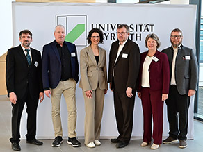 Vertreter der Universität Bayreuth, des StMUV, des LfU, der Kälte-Klima-Innung und der SHK-Innung vor dem Universitätslogo