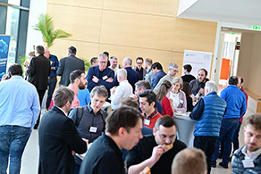 Tagungsteilnehmende unterhalten sich an Stehtischen