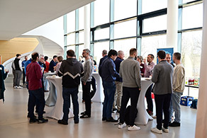 Tagungsteilnehmende unterhalten sich an Stehtischen