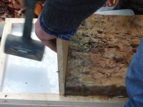 11. Mitarbeiter schließt Lücken zwischen den Bodenziegeln mithilfe einer Holzplatte, auf die vorsichtig gehämmert wird.