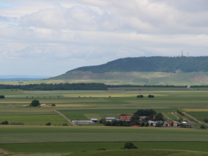 Ebene, landwirtschaftliche genutzte Terrasse des Mains vor prominenten Schichtstufen aus Gesteinen des Keupers (Schwanberg).