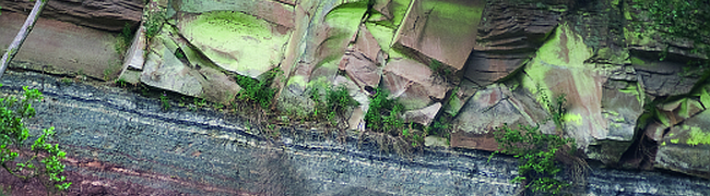 Detail der Bodenmühlwand mit rotbraunen, grauen und hellbraunen Gesteinen des Mittleren Keupers am Roten Main.