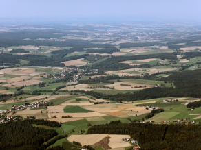 Luftbild: Strukturreiches Fichtelgebirge mit landwirtschaftlich genutzten Tälern und flach geneigten Hängen im Wechsel mit bewaldeten Höhenlagen.