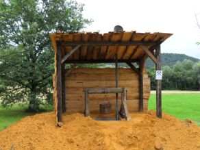 Nachbau eines Förderschachtes mit Winde und Belüftung umgeben von leuchtend ockergelbem Abbaumaterial. Nachbau eines Förderschachtes mit Winde und Belüftung umgeben von leuchtend ockergelbem Abbaumaterial.