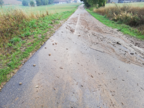 Teerstraße mit abgespülter Bodenmatrix vom angrenzenden Acker nach Starkniederschlägen