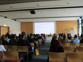 Participants are listening to the presentation in the conference hall.