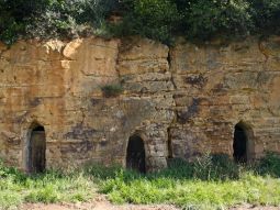 Drei Kellereingänge in der ockerfarbenen Sandsteinwand