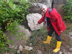 Ein LfU-Mitarbeiter mit roter Jacke zeigt auf einen Gesteinsbrocken im Steinbruch. In dem Gesteinsbrocken kann man bereits Knochenteile erkennen. Ein LfU-Mitarbeiter mit roter Jacke zeigt auf einen Gesteinsbrocken im Steinbruch. In dem Gesteinsbrocken kann man bereits Knochenteile erkennen.