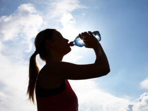 Eine Frau trinkt Wasser aus einer Flasche.