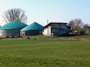 Auf dem Bild ist eine Biogasanlage bestehend aus Blockheizkraftwerk-Gebäude, Fermenter und Gärrestbehälter zu sehen.