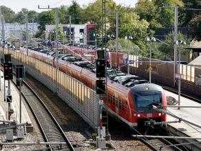 Mehrere Bahnsteige im Bahnhofsbereich. Eine Mittelwand zwischen zwei benachbarten Gleisen fungiert als gleisnahe Lärmschutzmaßnahme.