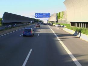 Zur Fahrbahn gekrümmte Lärmschutzwand an einer Autobahn.