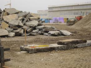 Betonbruchplatten aus dem Abbruch des alten Flugplatzgeländes werden aufgeschichtet zu Trockenmauern