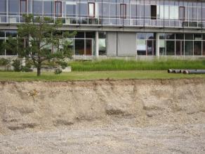 In der Baugrube des Labortraktes erkennt man Kiesuntergrund mit geringer Bodenauflage