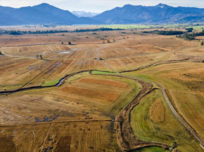 Luftbild einer Moorlandschaft, im Hintergrund die Alpen.