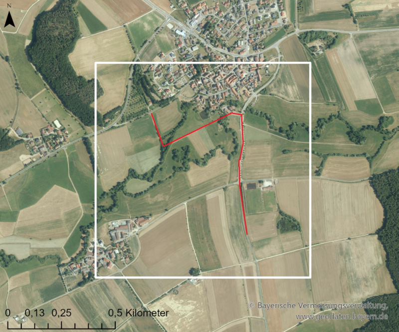 In ein Luftbild ist eine weiße quadratförmige Umrandung eingezeichnet. Sie zeigt die 1x1 km große Stichprobenfläche. Eine rote Linie entlang des bestehenden Wegenetzes stellt die Untersuchungsstrecke dar.