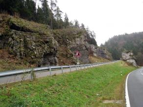 Landschaftsaufnahme mit Felsen im Hintergrund vor denen auf zwei Ebenen Straßen verlaufen, die eine ragt bis direkt an die Felsen heran