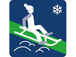 Ein Mensch fährt auf einem Schlitten auf einer grünen Spur den Berg hinunter,  mit Wintersymbol.
