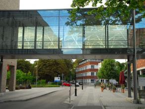 Glasbrücke zwischen Gebäuden mit hellen streifenförmigen Markierungen