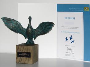 Bronze-Statuette des Baldhamer Künstlers Steffen Schuster als Danke für 50 Jahre Wasservogelzählung. Daneben die Urkunde, mit der noch zahlreiche ehrenamtlich Tätige Wasservogelzähler für 30 Jahre Zählung ausgezeichnet wurden.