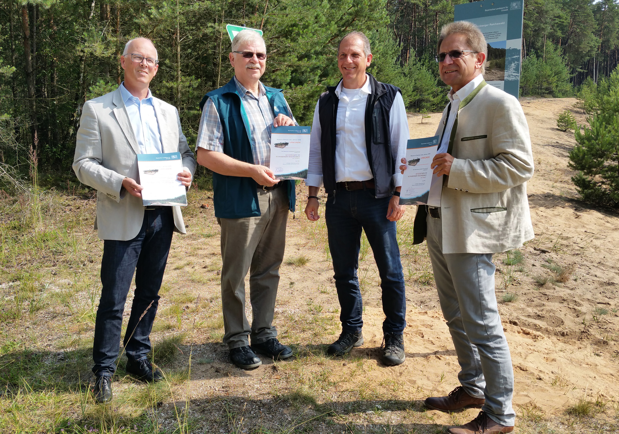 Nürnberger Sanddünen als Gestein des Jahres 2016 ausgezeichnet; v.l.n.r.: Bernd Hölzel (Leiter Kreisentwicklung Landkreis Nürnberger Land), Karlheinz Schuster (Vizepräsident Fränkischer Albverein), Roland Eichhorn (Leiter Geologischer Dienst am LfU) und Roland Blank (Leiter Forstbetrieb Nürnberg; Bayerische Staatsforsten) (Quelle: Bayerisches Landesamt für Umwelt) Nürnberger Sanddünen als Gestein des Jahres 2016 ausgezeichnet; v.l.n.r.: Bernd Hölzel (Leiter Kreisentwicklung Landkreis Nürnberger Land), Karlheinz Schuster (Vizepräsident Fränkischer Albverein), Roland Eichhorn (Leiter Geologischer Dienst am LfU) und Roland Blank (Leiter Forstbetrieb Nürnberg; Bayerische Staatsforsten)