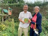 Gartenbesitzer Roland Gromer mit der Gartenbewerterin Angelika Heringlehner bei der Plakettenübergabe nach der Bewertung des Gartens