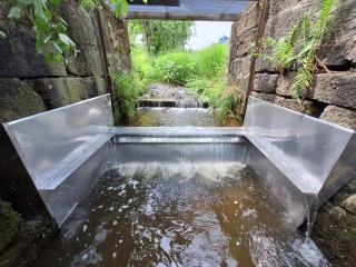 Zur Krebssperre umgebauter Sohlabsturz in Freyung-Grafenau. Alle rauen und vormals kletterbaren Teile wurden mit glatten und überstehenden Blechen umkleidet, sodass das Bauwerk von Flusskrebsen nicht länger überwunden werden kann.