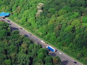 Luftaufnahme einer Autobahn, die ein Waldgebiet durchschneidet