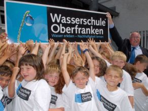 Schüler tragen ein Schild mit dem Schriftzug der Wasserschule