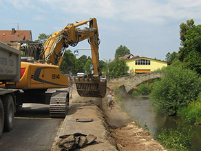 Ein Bagger beim Abbruch der alten Ufermauern an einem Fluss. Ein Bagger beim Abbruch der alten Ufermauern an einem Fluss.