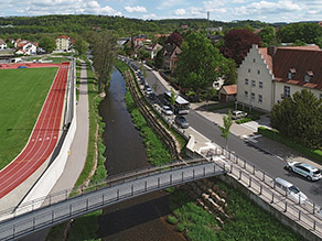 Luftaufnahme der Brend mit Blick flussabwärts auf den neuen Fußgängersteg und dein parallel zum Fluss verlaufenden Geh- und Radweg. Luftaufnahme der Brend mit Blick flussabwärts auf den neuen Fußgängersteg und dein parallel zum Fluss verlaufenden Geh- und Radweg.