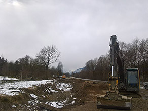 Das Gelände im Bereich des Hochwasserschutz Freilassing während der Baumaßnahme: Zwischen einer Straße und dem Mühlbach im neuen Flussbett eine schneebedeckte Fläche und das alte Flussbett. Rechts davon ein Bagger. Das Gelände im Bereich des Hochwasserschutz Freilassing während der Baumaßnahme: Zwischen einer Straße und dem Mühlbach im neuen Flussbett eine schneebedeckte Fläche und das alte Flussbett. Rechts davon ein Bagger.
