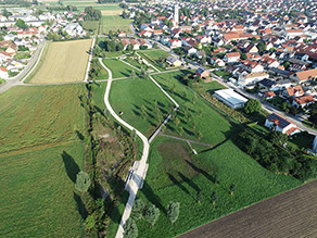 Luftaufnahme des Retzbachparks: Eine Grünanlage mit mehreren Geh- und Radwegen grenzt auf der einen Seite an einen renaturierten Bach und auf der anderen Seite an einen Siedlungsbereich. Luftaufnahme des Retzbachparks: Eine Grünanlage mit mehreren Geh- und Radwegen grenzt auf der einen Seite an einen renaturierten Bach und auf der anderen Seite an einen Siedlungsbereich.