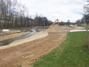 An den abgeflachten Ufern eines Flusses entsteht ein Kiesstrand und eine Sonneninsel. Im Hintergrund Kieshaufen und ein Bagger. An den abgeflachten Ufern eines Flusses entsteht ein Kiesstrand und eine Sonneninsel. Im Hintergrund Kieshaufen und ein Bagger.