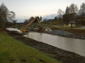 Ein Bagger arbeitet in einem Fluss stehend. Ein Bagger arbeitet in einem Fluss stehend.