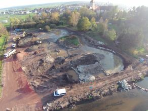 Luftaufnahme einer Baustelle am Ufer eines Flusses: Zu erahnen ist der Verlauf einer neuen Flussschleife, die gerade entsteht. Mehrere Bagger und ein Lastkraftwagen befinden sich im Hintergrund. Luftaufnahme einer Baustelle am Ufer eines Flusses: Zu erahnen ist der Verlauf einer neuen Flussschleife, die gerade entsteht. Mehrere Bagger und ein Lastkraftwagen befinden sich im Hintergrund.