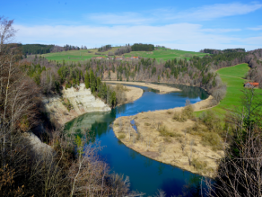 Blick von einem Aussichtspunkt auf eine Flusslandschaft mit einer s-förmig gewundenen Flussschleife, einem steilen Prallufer auf der einen und einem flachen Gleitufer auf der anderen Seite. Blick von einem Aussichtspunkt auf eine Flusslandschaft mit einer s-förmig gewundenen Flussschleife, einem steilen Prallufer auf der einen und einem flachen Gleitufer auf der anderen Seite.