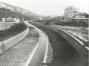 Historische Aufnahme der Sulz nach dem technischen Ausbau: Ein Bach fließt in einem Flutgraben mit Kastenprofil und durch Ufermauern von den angrenzenden Ackerflächen getrennt.