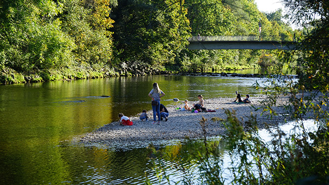 Auf einer Kiesbank im Fluss hocken Kinder und spielen mit Steinen. Auf einer Kiesbank im Fluss hocken Kinder und spielen mit Steinen.