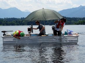 In einem Boot sind drei Mitarbeiter der Wasserwirtschaftsverwaltung, die unterschiedliche Untersuchungen vornehmen. Ein Mitarbeiter ermittelt mit Hilfe der Secchischeibe die Sichttiefe. Ein weiterer Mitarbeiter zieht mit einem Schöpfer eine Wasserprobe, der dritte Mitarbeiter misst mit einer Multiparametersonde physikalische Parameter in unterschiedlichen Tiefenstufen.