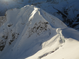 Große Schneewechte oberhalb einer Skiaufstiegsspur