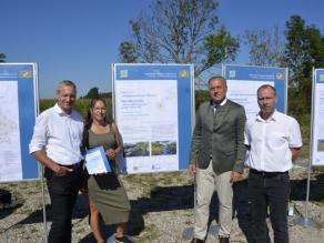 Die Preisträger und MD Dr. Detsch stehen links und rechts neben dem Preisträgerplakat. Eine Person hält eine Urkunde in der Hand.