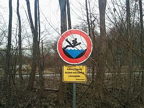 Ein Schild weist auf eine besondere Gefahr an einem Gewässer hin