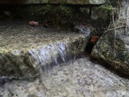 Quellwasseraustritt einer in Granit gefassten Quelle