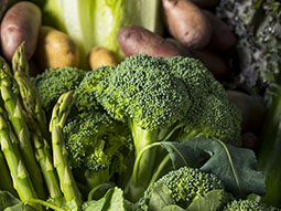 Gemüsefoto mit Brokkoli, hellen und roten Kartoffeln, grünem Spargel, Gurke und Salat.