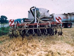 Ein Traktor bringt Flüssigdünger auf eine Wiese aus