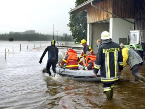 Schlauchbooteinsatz bei Hochwasser von Feuerwehr und Wasserwacht zur Evakuierung der Anwohner eines landwirtschaftlichen Hofs.