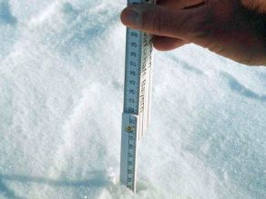 Ein Meterstab wird in den Schnee gesteckt und abgelesen.