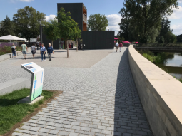 Menschen spazieren entlang der im Zuge der Gartenschau errichteten Hochwasserschutzwand.