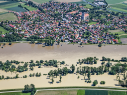 Die Luftaufnahme wurde während des Hochwassers in Niederalteich an der Donau im Jahr 2010 aufgenommen – die Siedlung ist durch Hochwasserschutzmaßnahmen (hier: Deich) geschützt.